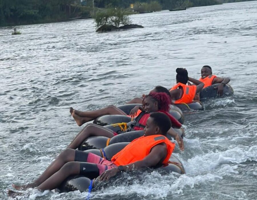 Travellers in life jackets floating on tubes through the rapids on the Nile at Jinja